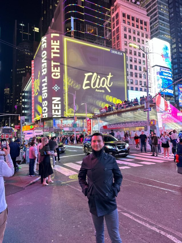 Diego Plaza en Times Square frente a la pantalla de Eliot Awards.