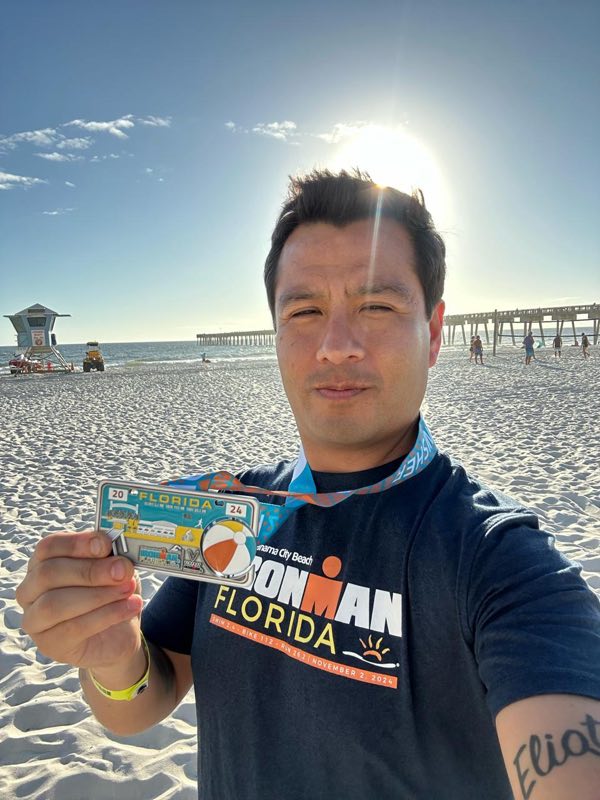 Diego Plaza con su medalla de Ironman Florida en la playa.