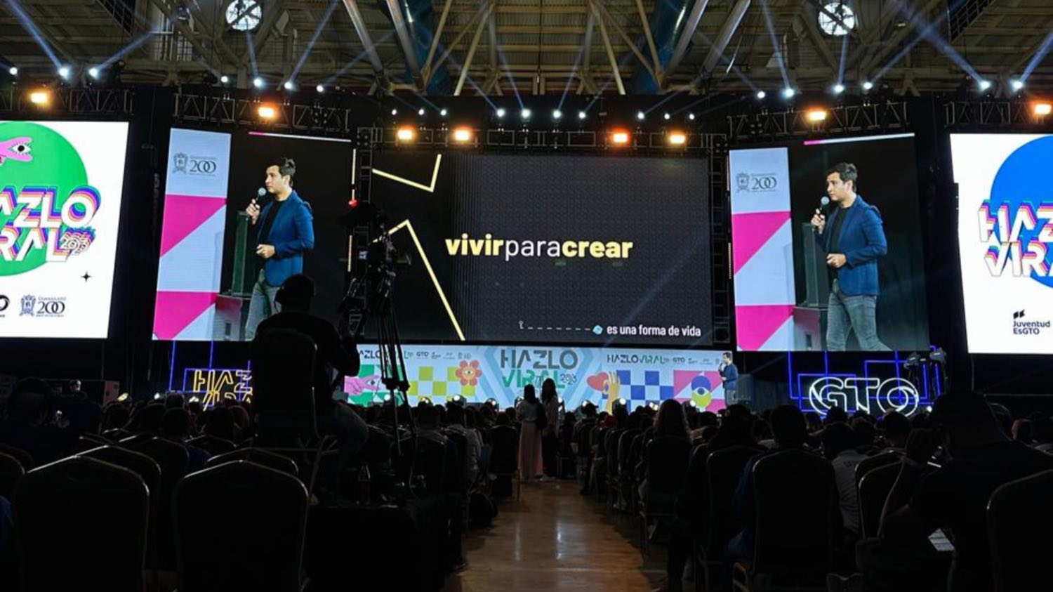 Diego Plaza en el escenario de Hazlo Viral, frente a una pantalla que dice «vivir para crear».